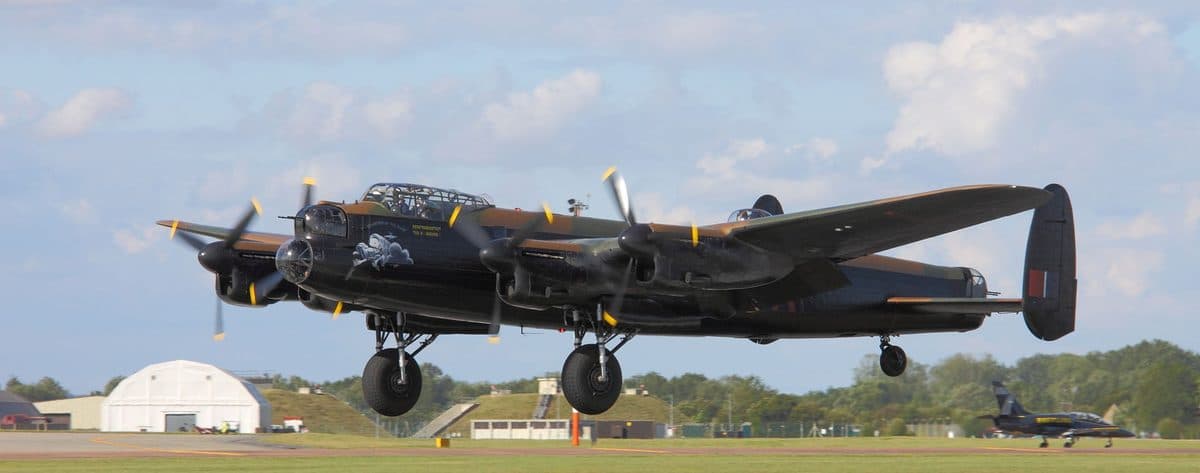 Avro Lancaster heavy bomber in flight showing its four Merlin engines and distinctive twin-tail configuration
