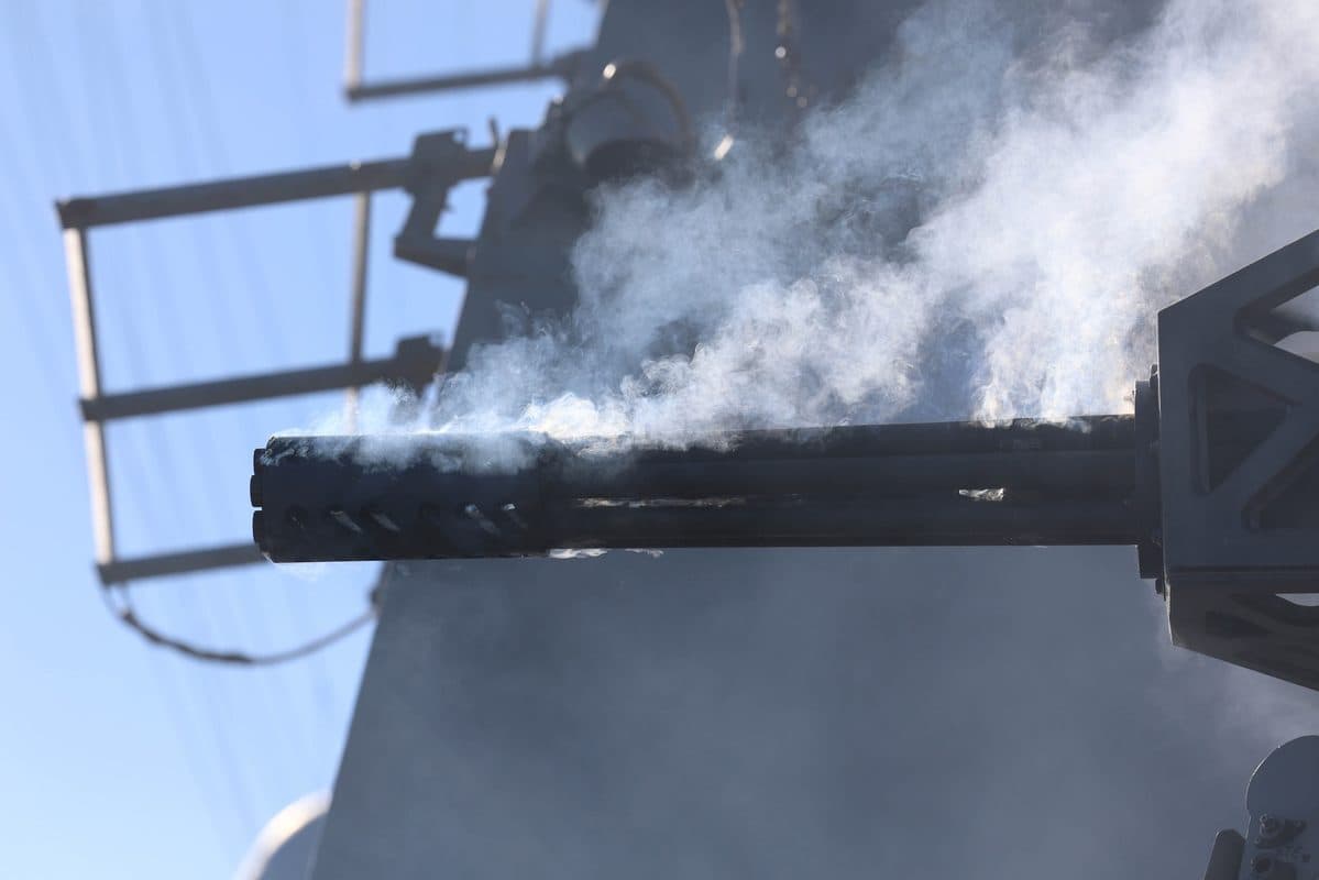 Phalanx CIWS close-in weapon system firing during a live-fire exercise aboard a U.S. Navy destroyer with smoke rising from the barrel
