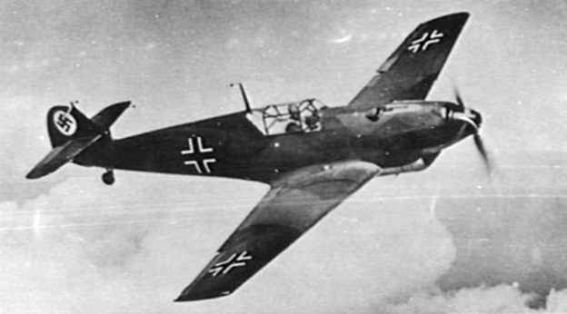Messerschmitt Bf 109 in Luftwaffe markings flying low over terrain