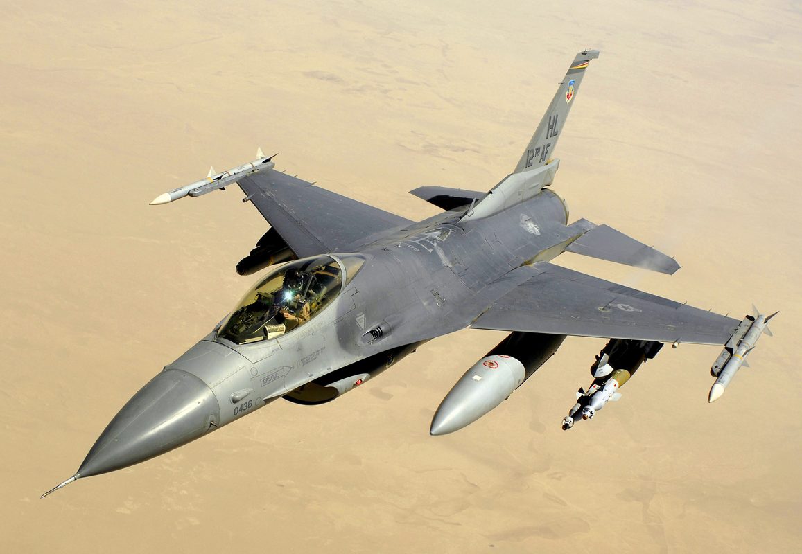 F-16 Fighting Falcon performing a high-G turn with vapor trails