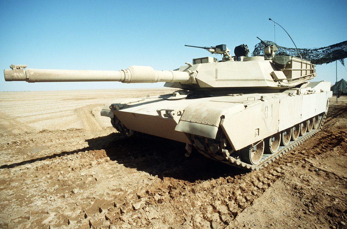 M1A2 Abrams main battle tank firing its 120mm gun during live-fire exercise with American flag