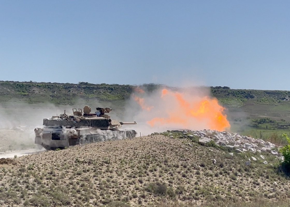 M1 Abrams tank showing scorch marks and surface damage from RPG impacts on the hull and turret