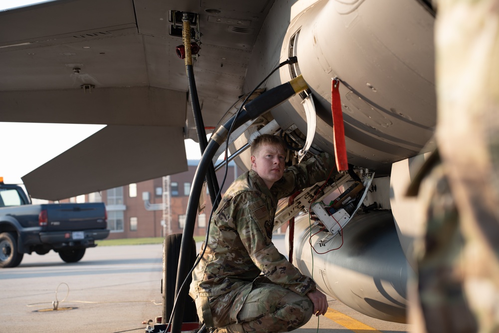 Technicians performing software and systems upgrades on military aircraft