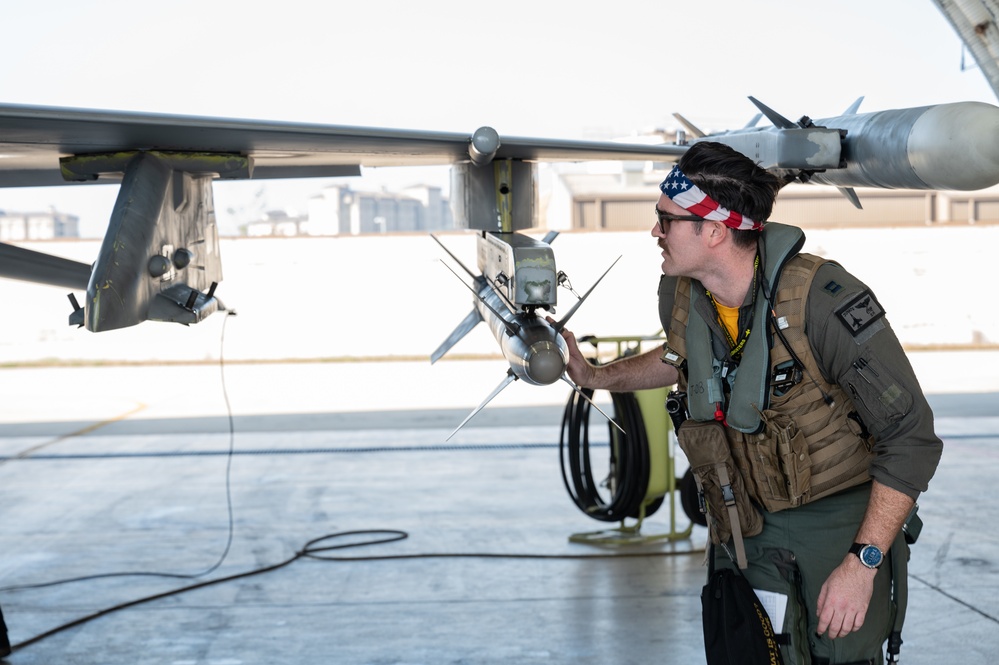 Ground crew members performing preflight checks on military aircraft