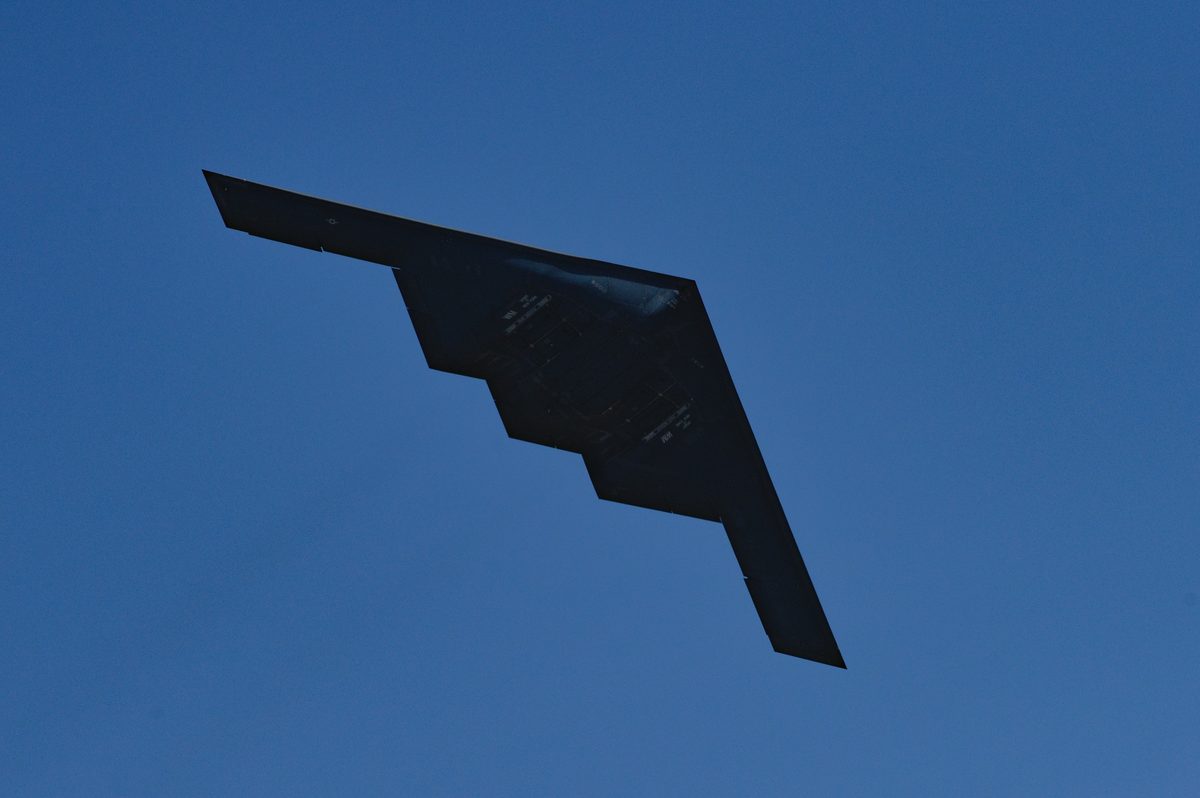 B-2 Spirit performing a low flyover at an air show, displaying the full flying wing shape against a clear sky