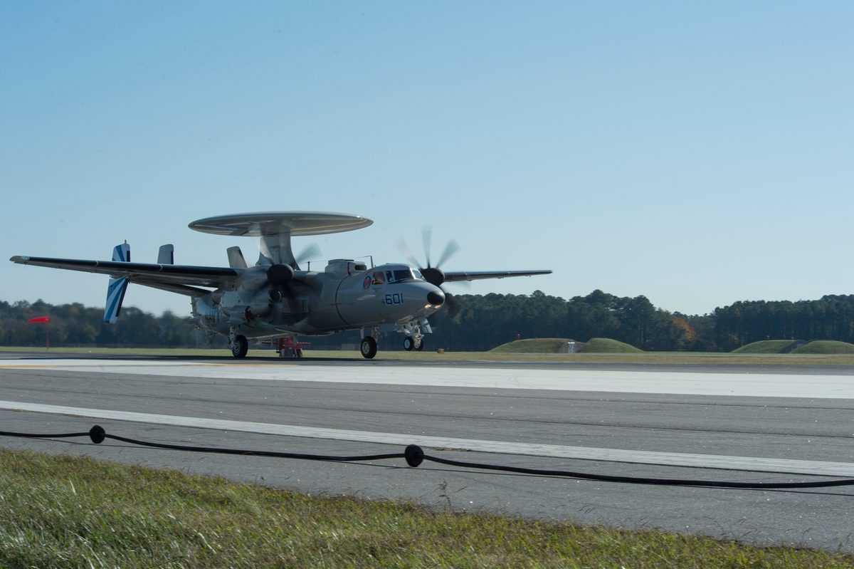 E-2D Advanced Hawkeye aircraft launching from an aircraft carrier flight deck for airborne early warning patrol