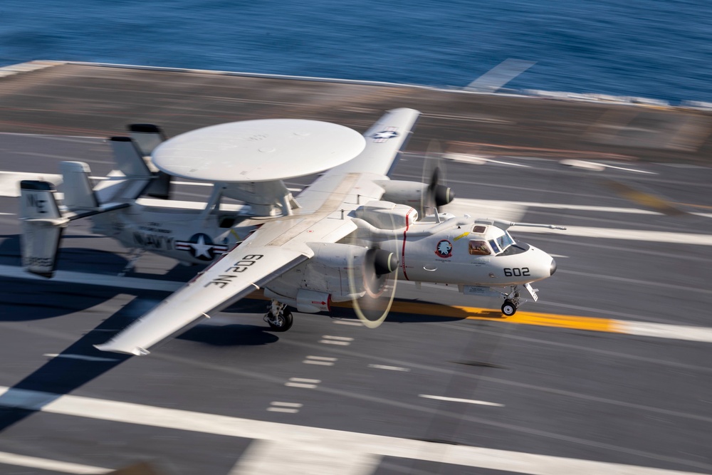 Aircraft carrier flight deck operations with aircraft being prepared for launch