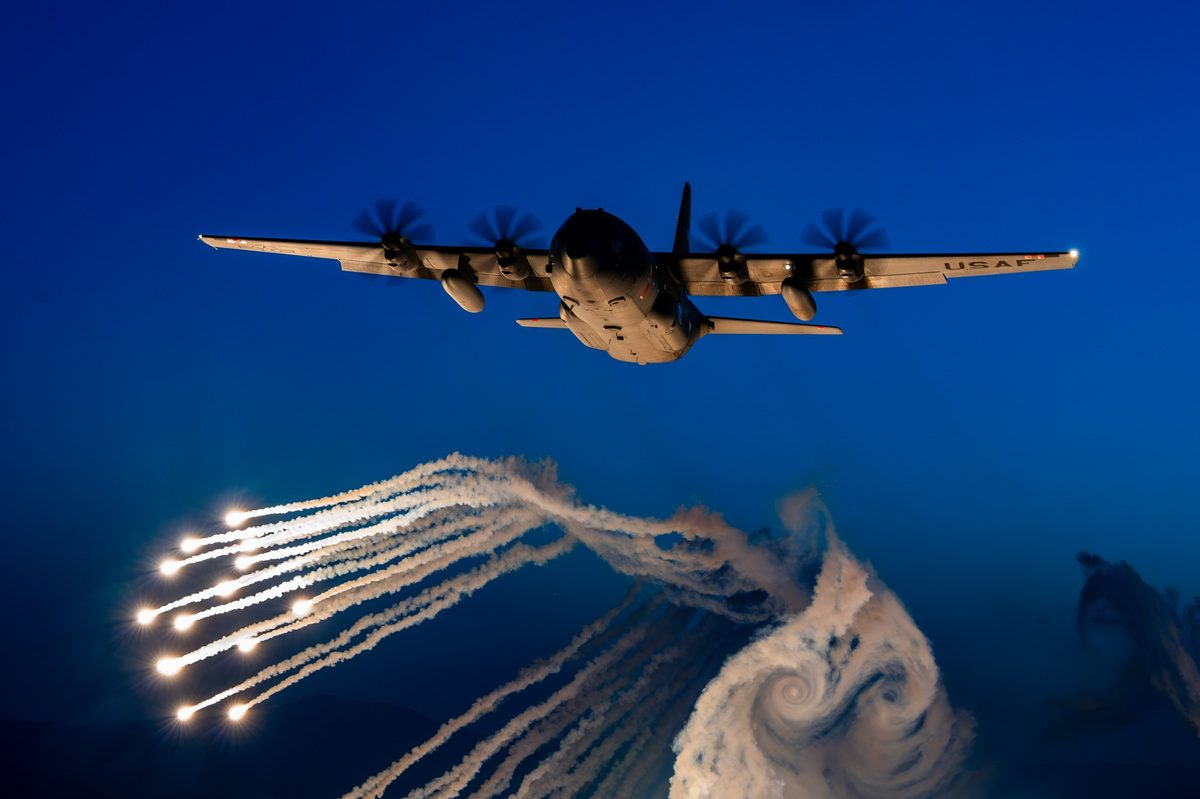 A C-130 Hercules from the 153rd Airlift Wing fires flares over Camp Guernsey during a training mission