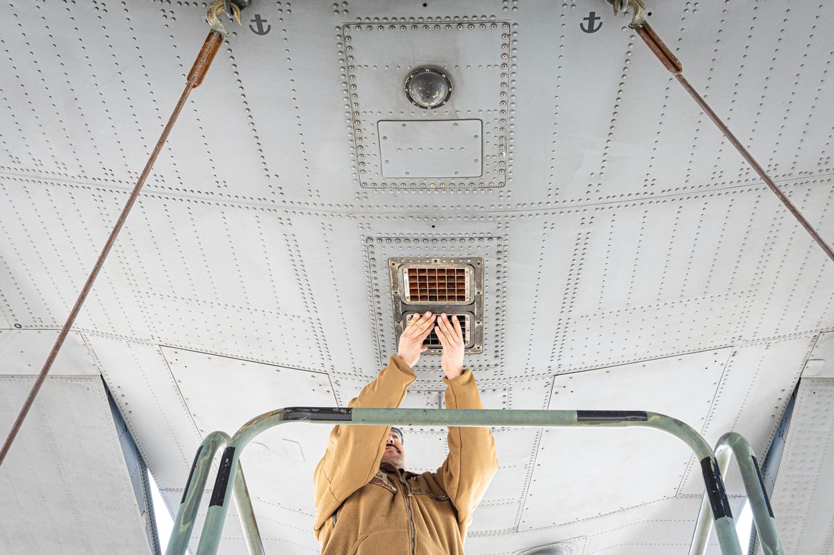 U.S. Air Force maintainers inspect and install chaff and flare cartridges into the AN/ALE-47 countermeasure dispenser on a C-130H Hercules