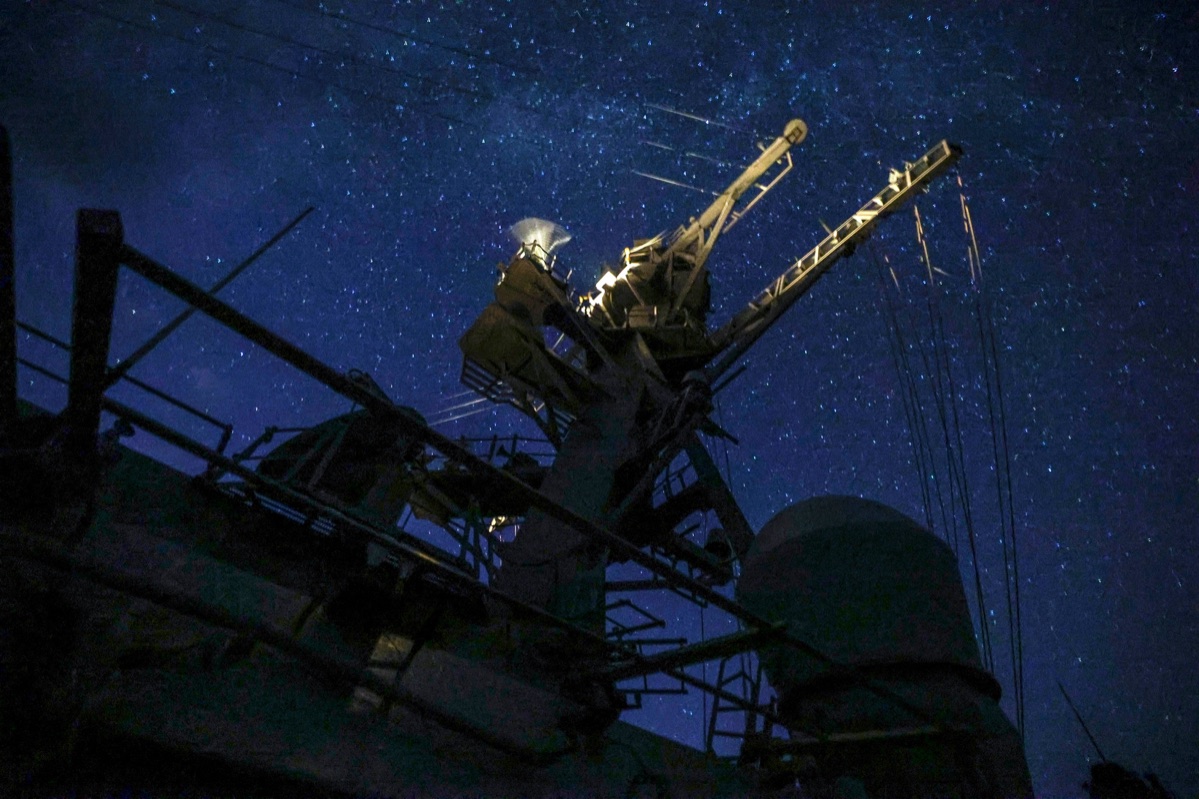 Arleigh Burke-class destroyer SPY radar arrays illuminated at night