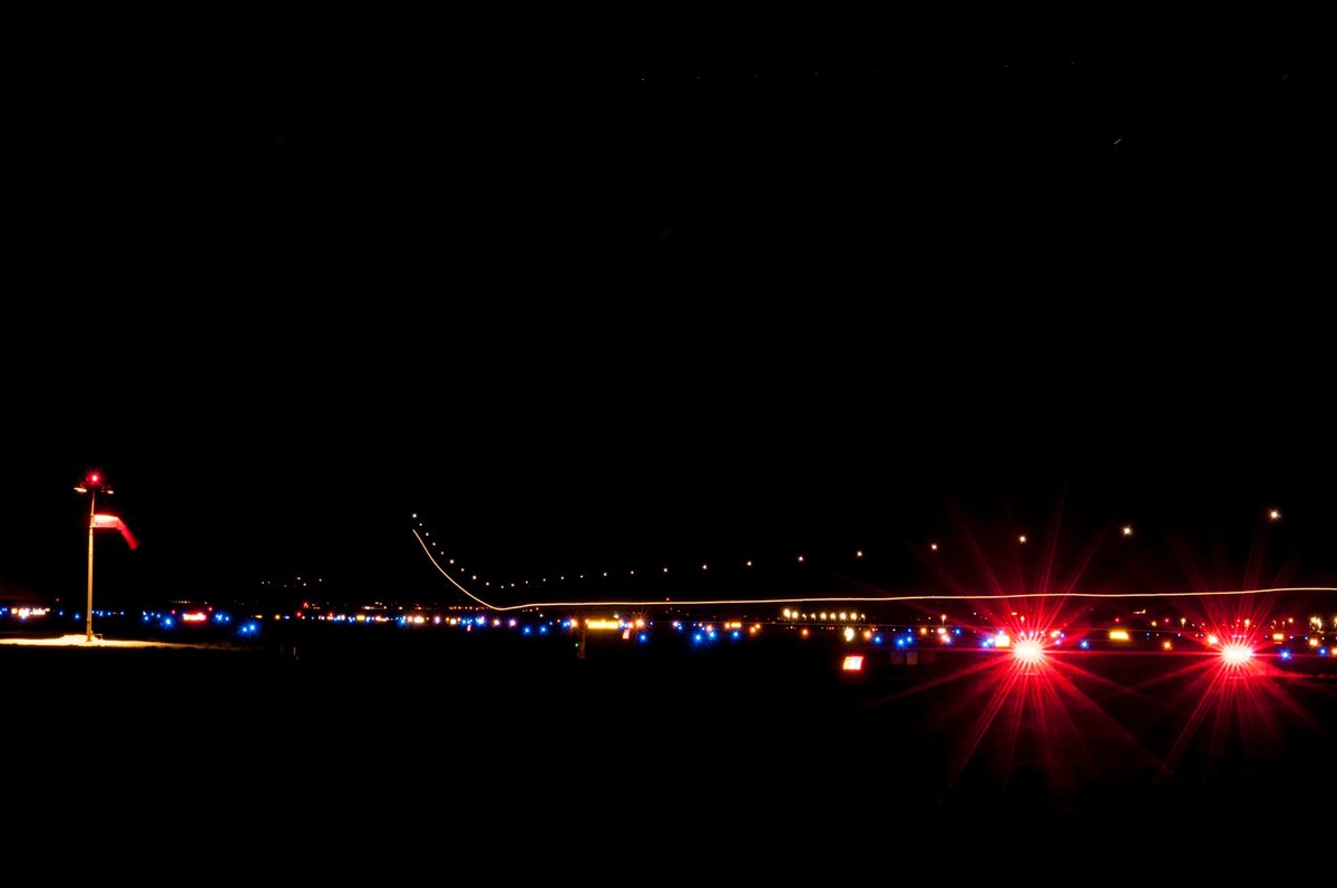 Long-exposure photograph showing F-16 afterburner and strobe light trails during a night training mission