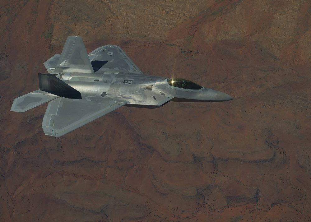 F-22 Raptor in a banking turn during flight, showing its distinctive diamond-shaped wing planform and twin vertical stabilizers