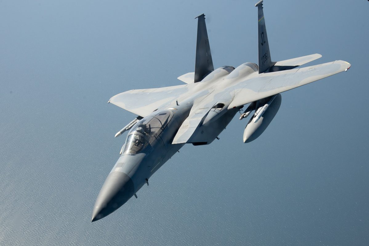 F-15E Strike Eagle in flight over water showing its twin-engine twin-tail profile