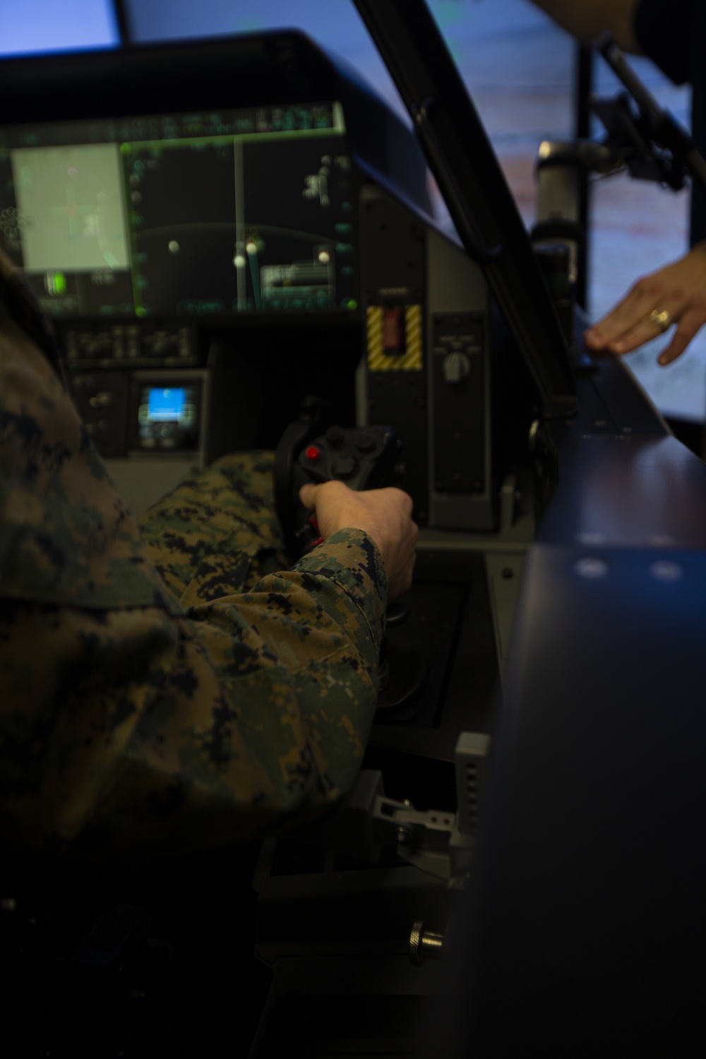 Marine operating an F-35 cockpit demonstrator, showing the advanced displays and sensor integration systems