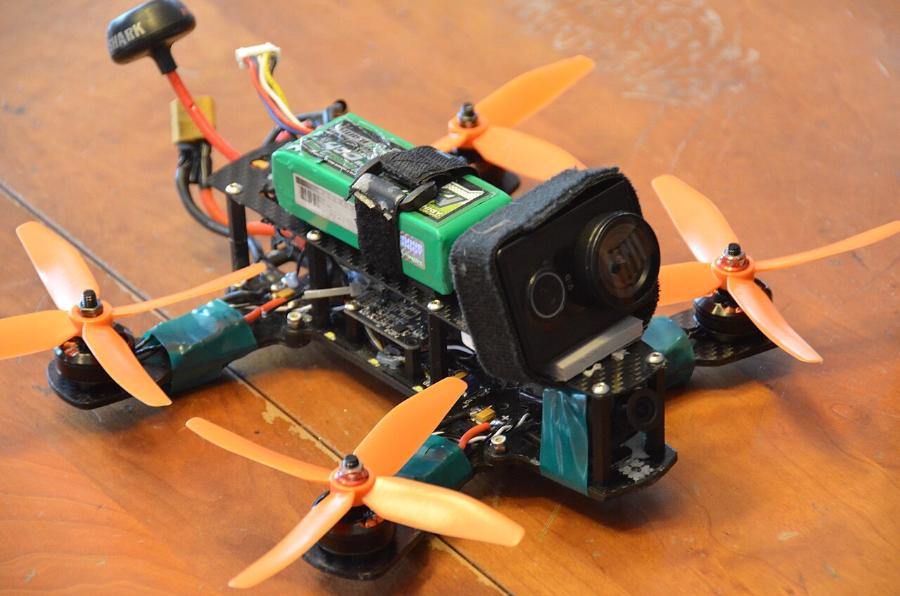 First-person-view combat drone equipped with a shaped-charge warhead in flight over a Ukrainian battlefield
