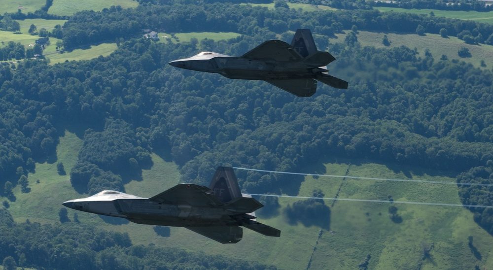 Two F-22 Raptors flying in formation over Virginia, demonstrating the aircraft that IRST systems are designed to detect