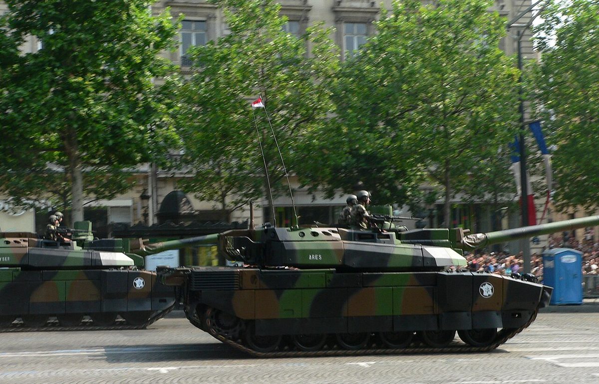 Leclerc tanks parading on a tree-lined Paris boulevard