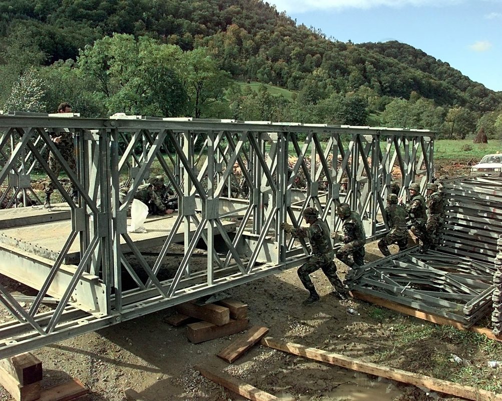 U.S. Army engineers pushing a military bridge into position during construction in Bosnia