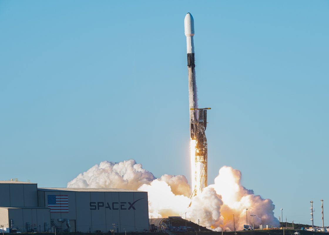 Military satellite launch from Vandenberg Space Force Base showing rocket ascending through clouds