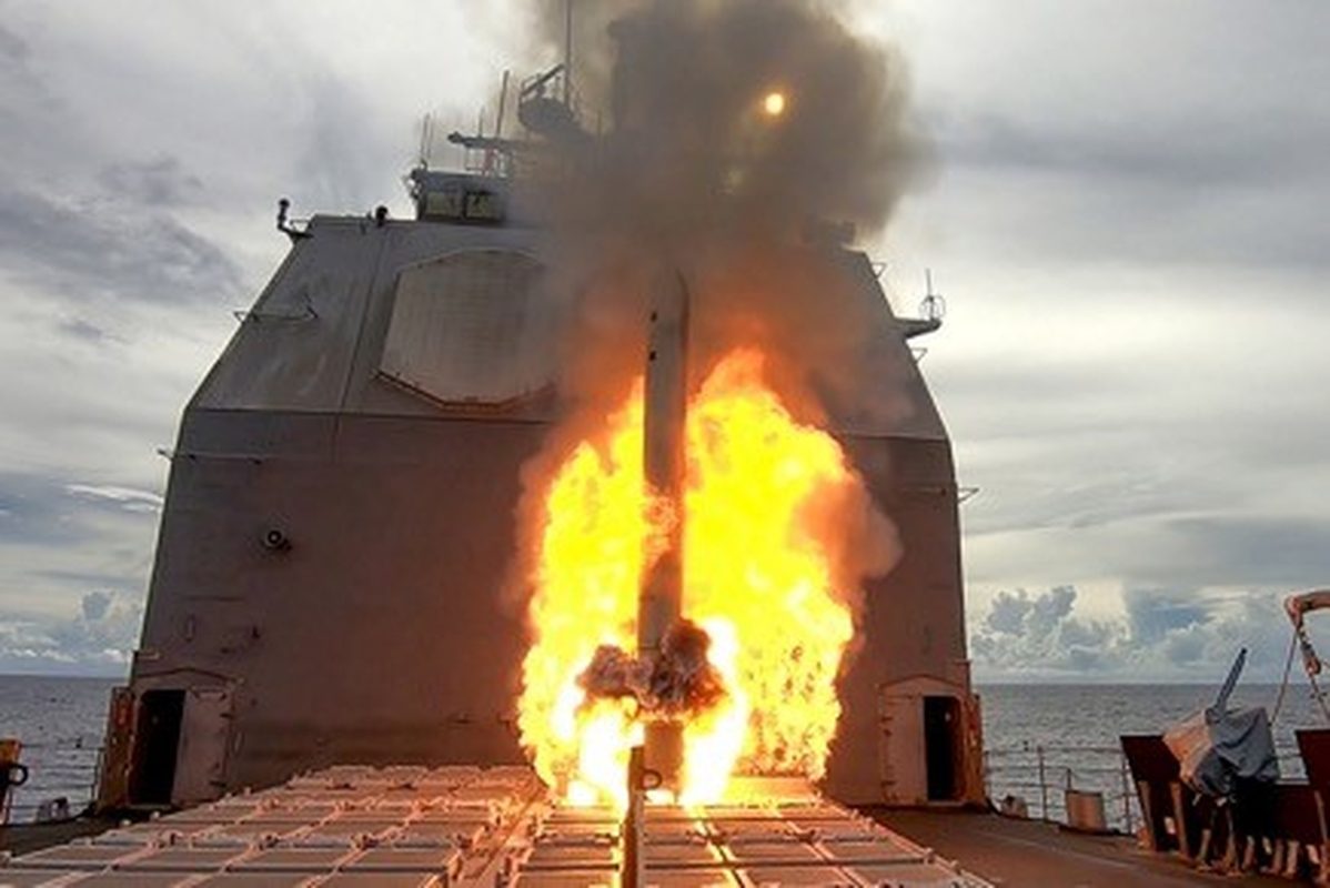 Tomahawk cruise missile launching from guided-missile cruiser with flame and smoke trail
