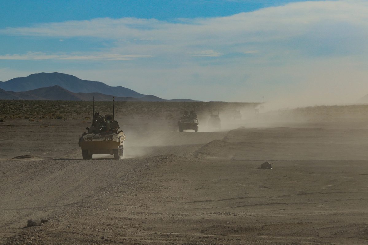 Main battle tanks and OPFOR surrogate vehicles push forward during a force-on-force exercise at the Whale Gap, National Training Center