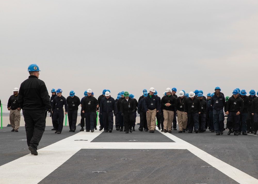 Sailors conduct a FOD walkdown on the flight deck of USS Gerald R. Ford