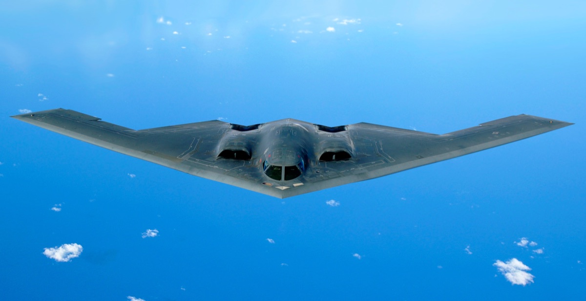 B-2A Spirit stealth bomber flying overhead showing its smooth flying wing shape and blended surfaces