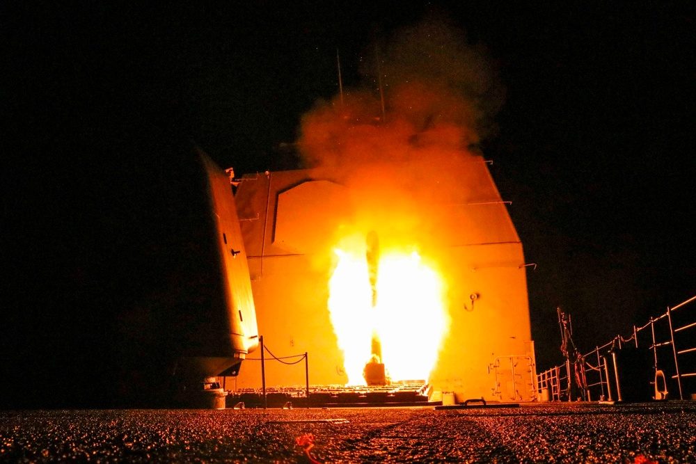 Tomahawk cruise missile launching from a warship's vertical launch system at night